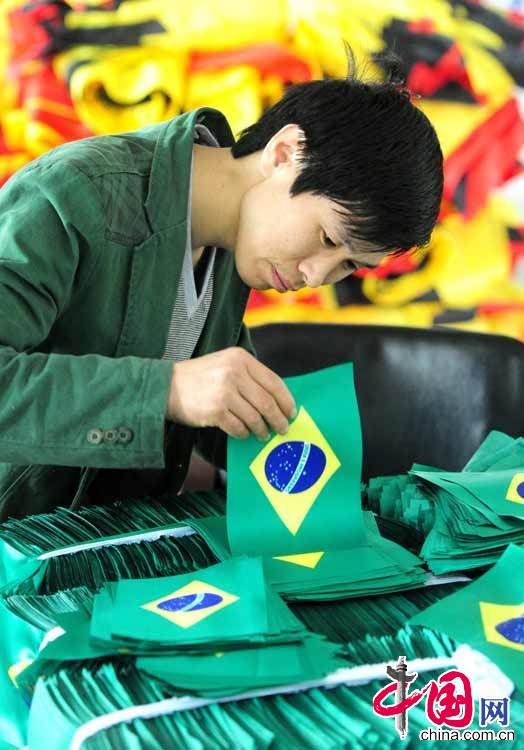 2014年4月9日，某公司員工在整理剛裁剪出來的巴西手搖國旗。中國網圖片庫 張建成攝影