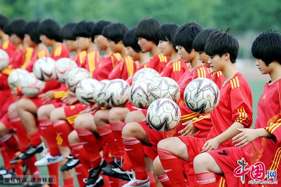 图为“足球丫头”们在学校足球场练习基本动作