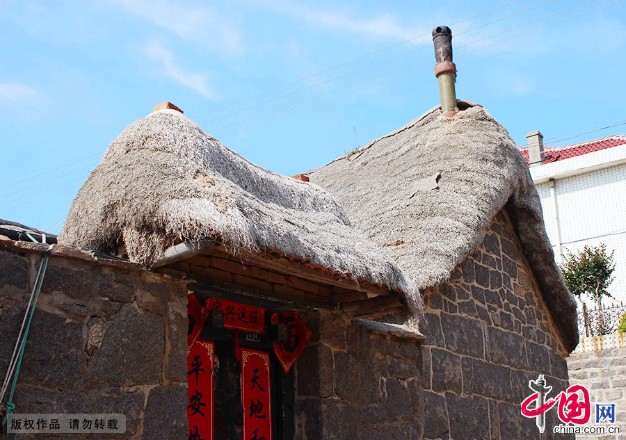 在原始石块或砖石块混合垒起的屋墙上，有着高高隆起的屋脊，屋脊上面是质感蓬松、绷着渔网的奇妙屋顶。