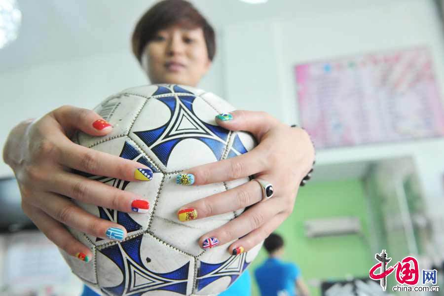 6月14日，在浙江省臨安市一家美甲店，一名女球迷在展示做好的世界盃美甲。 中國網圖片庫 胡劍歡攝影