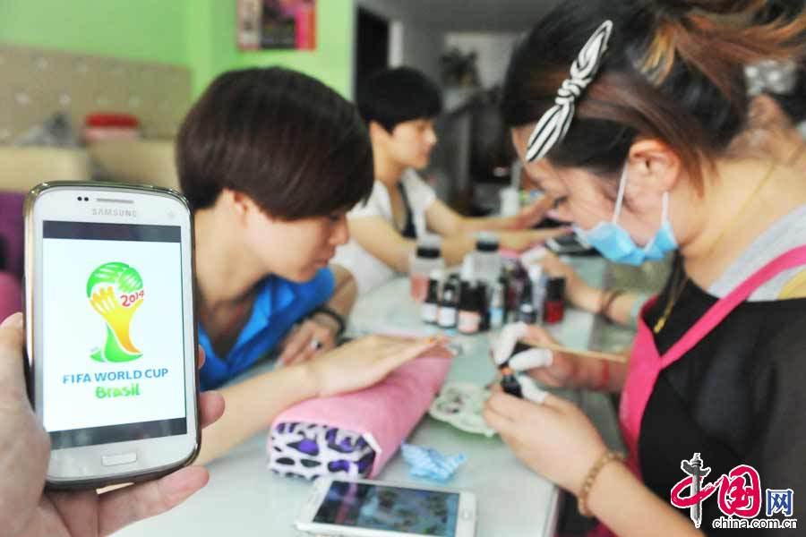 2014年06月14日，在浙江省臨安市一家美甲店，一名女球迷在做世界盃美甲。 中國網圖片庫 胡劍歡攝影