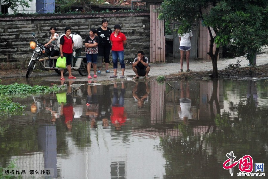6月19日，在福建省厦门市海沧区后坑村，几名村民站在积水严重的村道上。