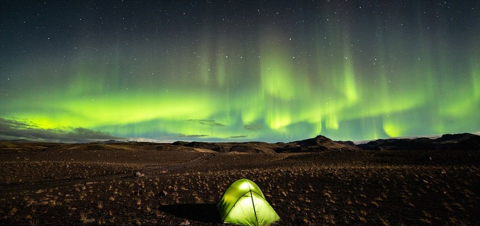 冰岛南端仰望苍穹，绚丽多彩的北极光下，连帐篷也染上一片神秘之色。