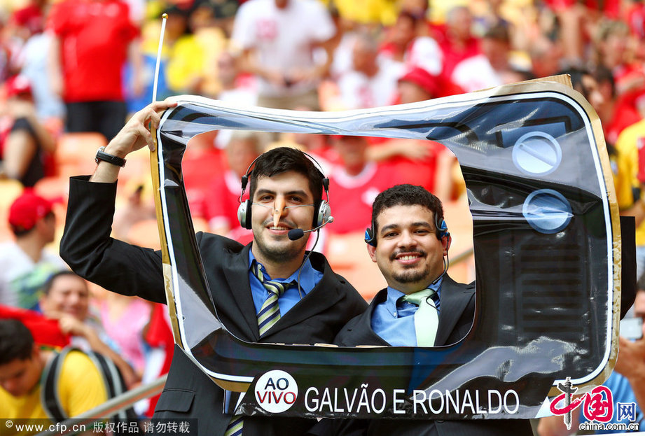2014年6月25日，巴西亞馬遜競技場，2014巴西世界盃小組賽E組，宏都拉斯Vs瑞士。球迷裝扮成解説員模樣在看臺上加油。Clive Brunskill/Getty Images/CFP