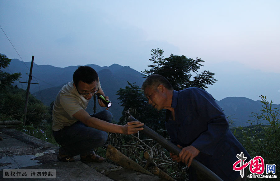  一天傍晚，胡灵仙和村民胡维民老人查看水源，了解饮用水不稳定的原因。