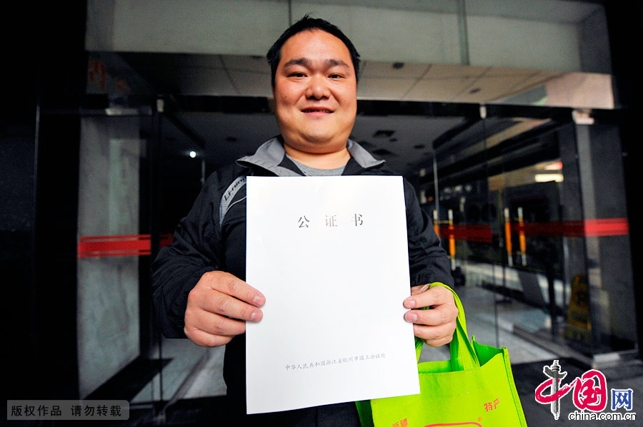 杭州开始发放首批购车申请公证书，一位市民拿到了公证书。