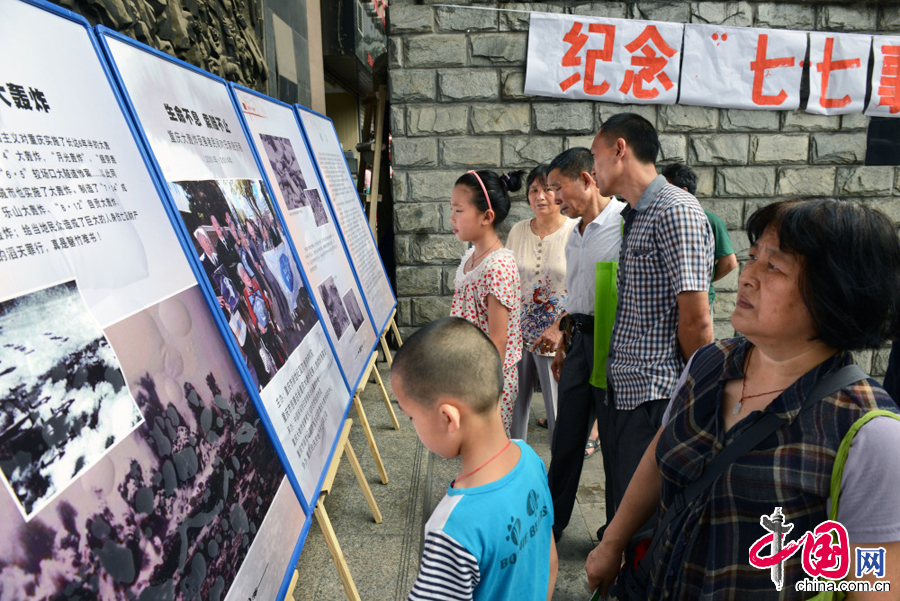 市民在纪念全民族抗战爆发77周年活动现场，观看“重庆大轰炸”历史图片展，缅怀遇难同胞。中国网图片库 渝钟摄影