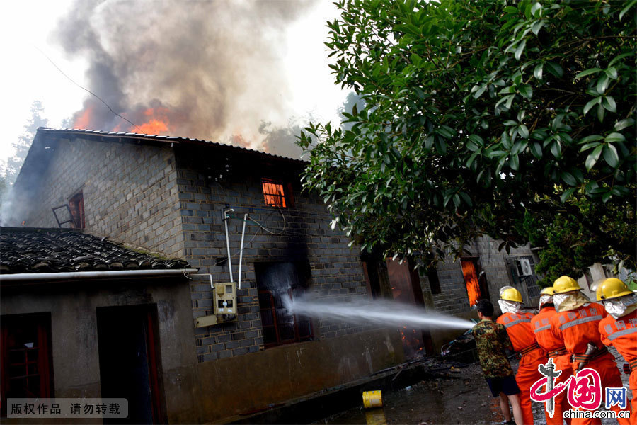  7月8日，江西省德兴市泗洲镇泗州小学对面的一座民房发生火灾，消防员在事故现场灭火。