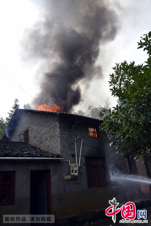  7月8日，江西省德興市泗洲鎮泗州小學對面的一座民房發生火災，消防員在事故現場滅火。