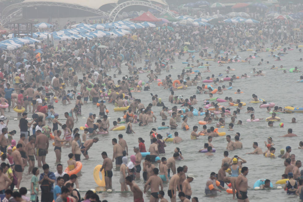 青島持續高溫 海濱浴場遊客扎堆如“下餃子”