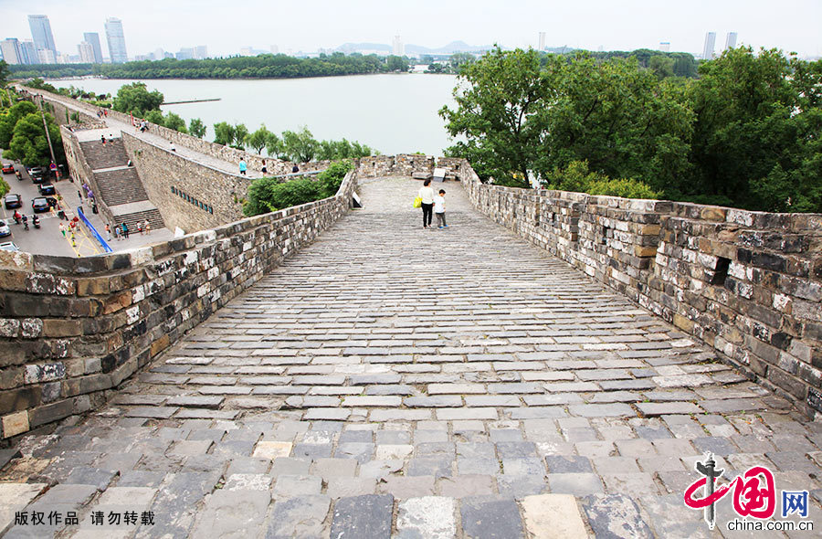 图为南京明城墙台城段，远处是南京市区的高楼大厦和玄武湖。