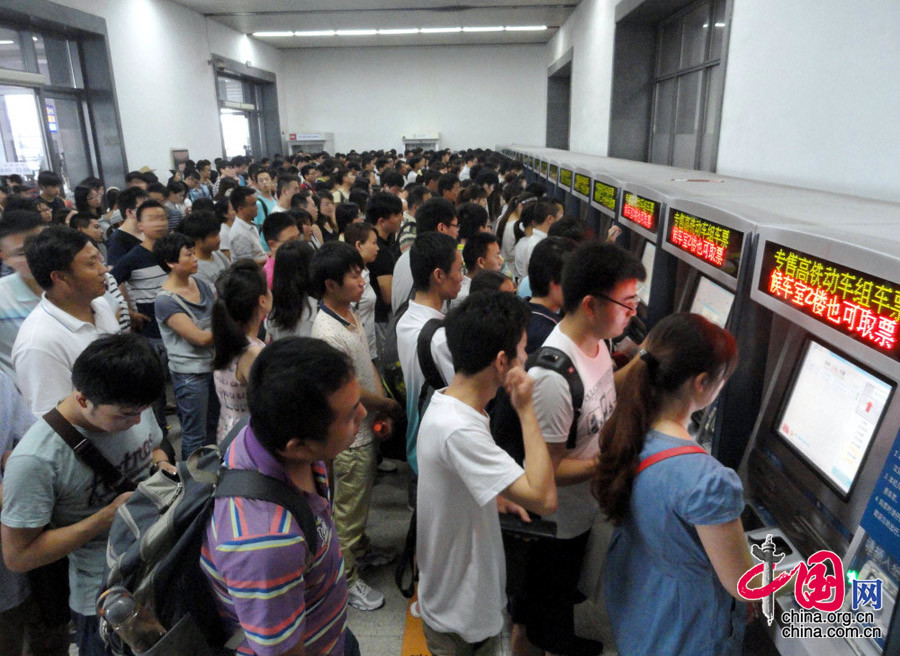 旅客在蘇州火車站自助售票機前排隊購買火車票。