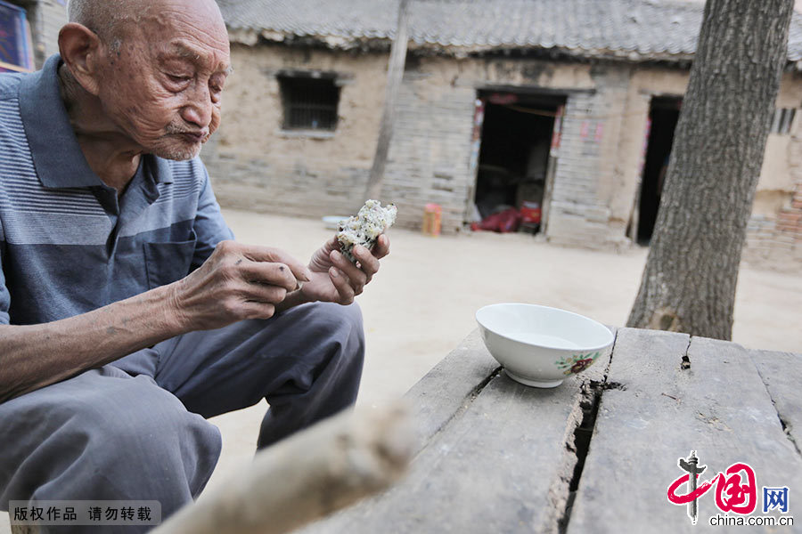 在屋外，齊修體就著蒜瓣兒，津津有味地啃起了“菜窩窩”，好在老人的身板很結實。