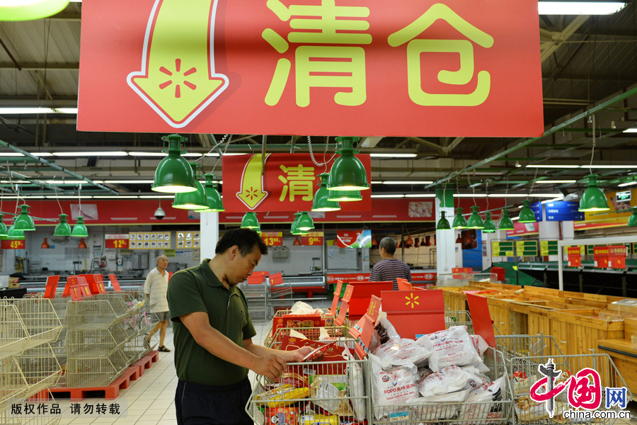 2014年7月28日，浙江省杭州市，顧客在沃爾瑪杭州鳳起店裏選購尾貨。