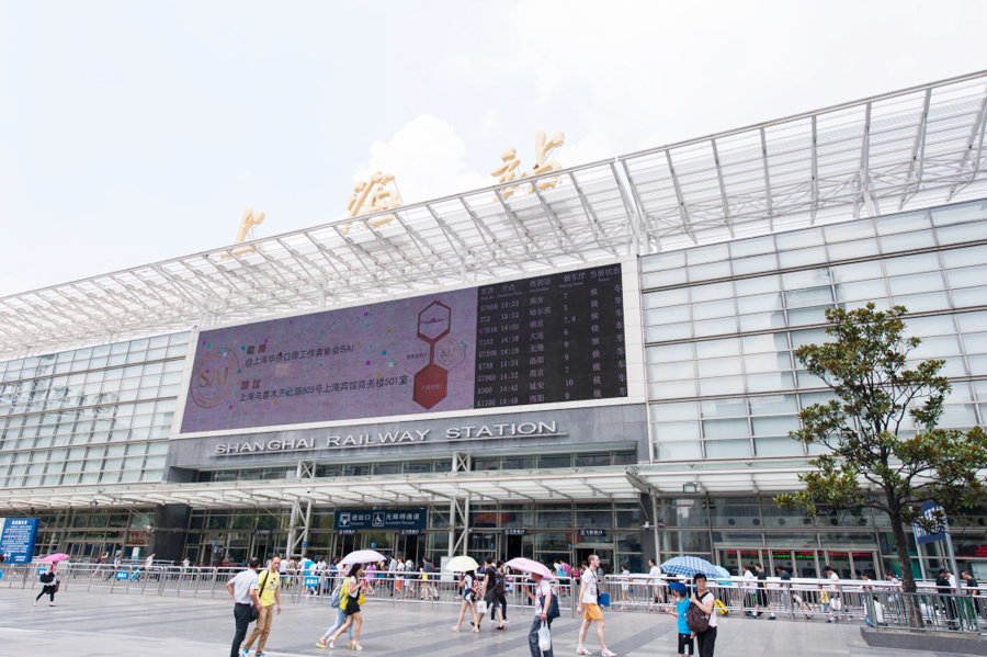  2014年07月29日，上海，今天中午十二时，尽管天气炎热，铁路上海站站前广场上人来人往，十分繁忙。人工售票大厅售票窗口前排起了长队，自助售票处和展厅进口处人流相当密集。 中国网图片库 王冈摄影