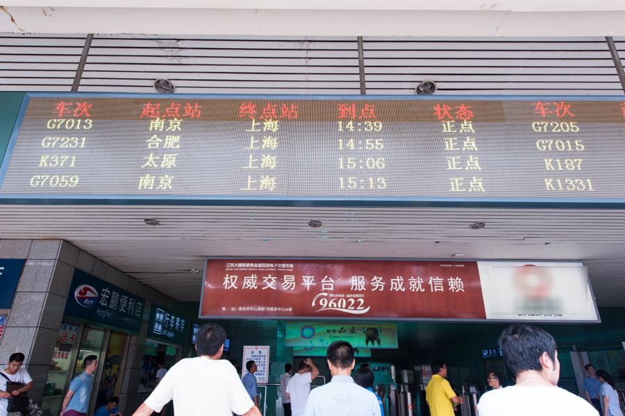  2014年07月29日，上海，今天中午十二时，尽管天气炎热，铁路上海站站前广场上人来人往，十分繁忙。人工售票大厅售票窗口前排起了长队，自助售票处和展厅进口处人流相当密集。 中国网图片库王冈摄影