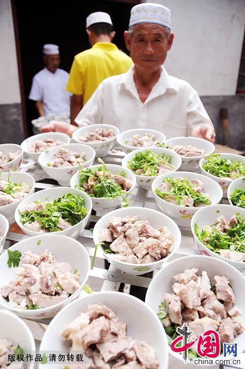 7月29日，一名清真餐馆员工展示自己烹制的清炖羊肉。