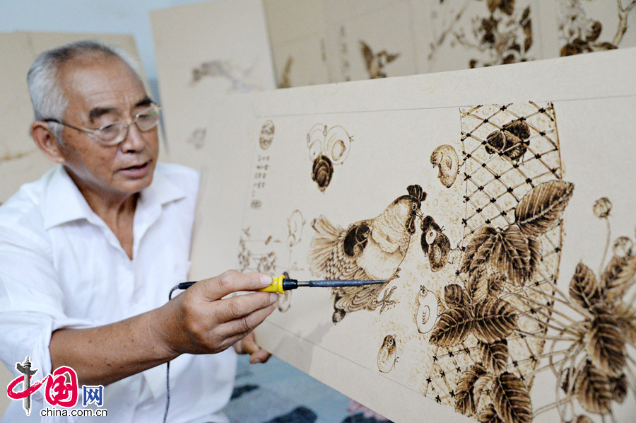 7月30日，河北省邯郸市邯郸县榆林村民间艺人张振芳正在用电烙铁作画。
