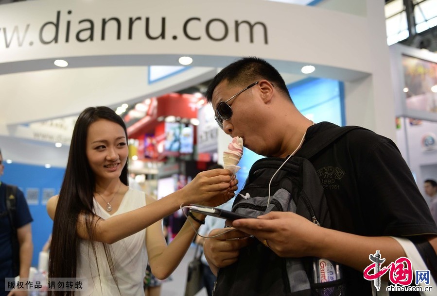 7月31日，一名 show girl在中國國際數位互動娛樂展覽會上喂漫迷吃冰淇淋。