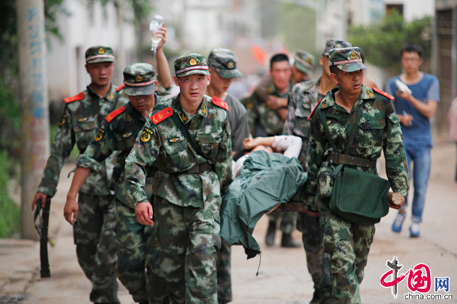 2014年8月3日，云南鲁甸发生6.5级地震，鲁甸龙头山镇地震现场，人们在余震中救死扶伤。图片来源：CFP