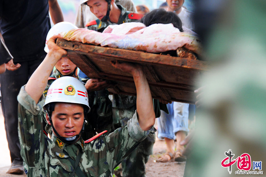 2014年8月4日，云南昭通，武警云南总队曲靖支队官兵在龙头山镇转移受伤群众。图片来源：CFP