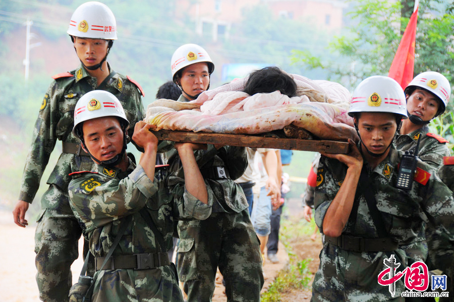 2014年8月4日，云南昭通，武警云南总队曲靖支队官兵在龙头山镇转移受伤群众。图片来源：CFP