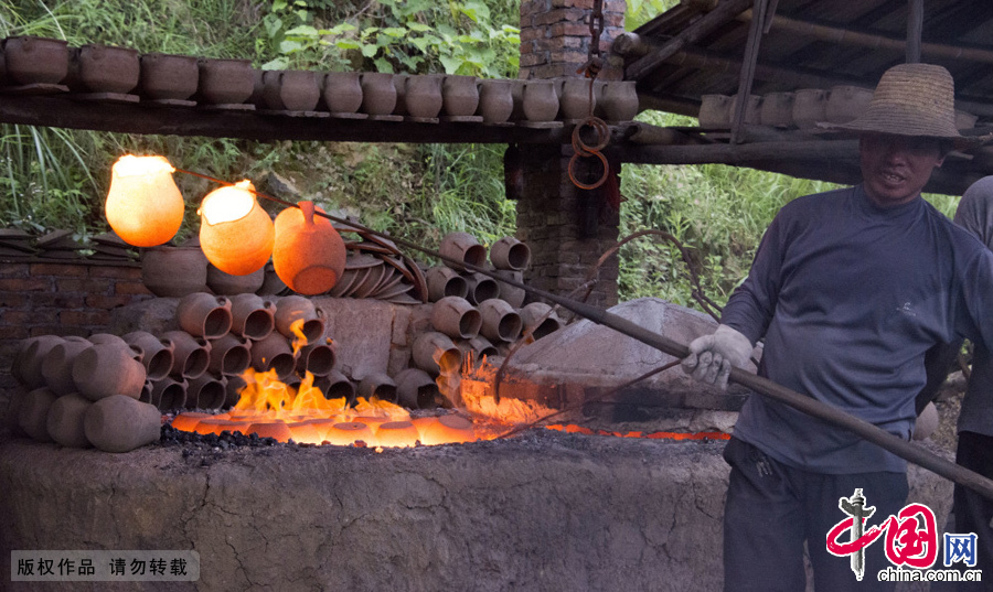 工匠们正在烧制好的砂罐从炉灶中取出