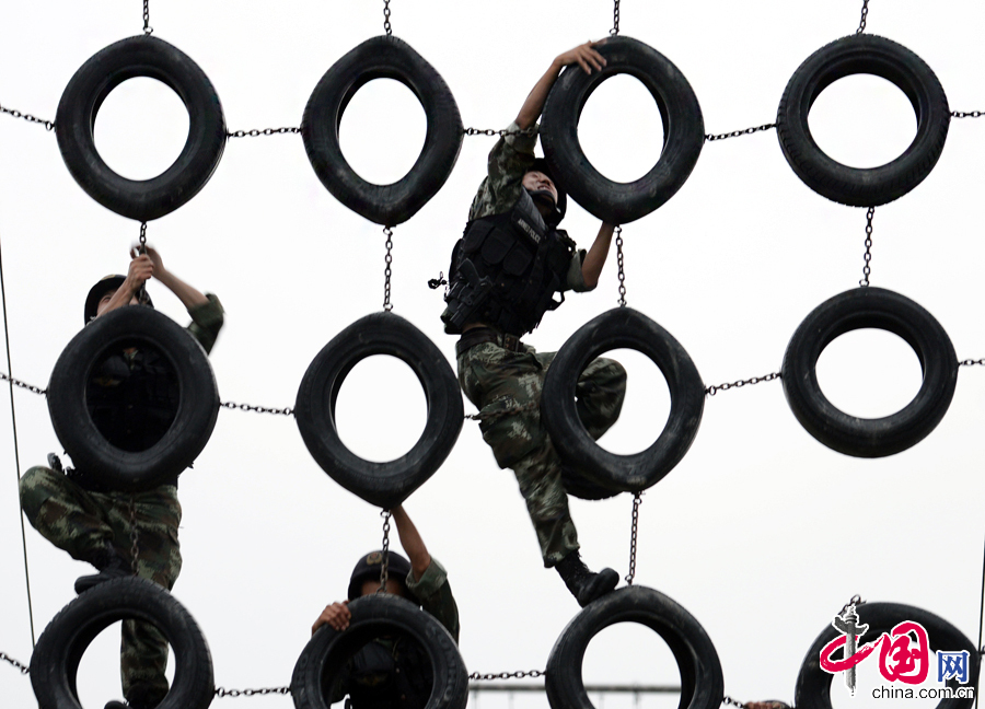 8月6日，武警江苏某部特战队员冒着高温进行翻越障碍训练。