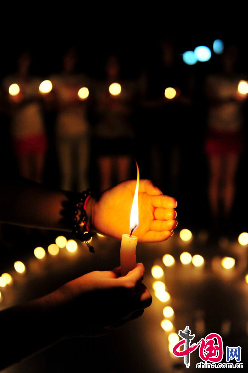 2014年8月7日，安徽省含山县博物馆广场前，该县青年志愿者点燃蜡烛，为云南鲁甸地震灾区遇难同胞祈福。中国网图片库李昌兵摄影