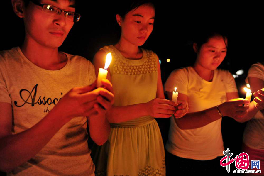 2014年8月7日，安徽省含山县博物馆广场前，该县青年志愿者点燃蜡烛，为云南鲁甸地震灾区遇难同胞祈福。中国网图片库李昌兵摄影