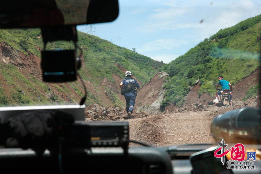 王剛“前出探路”，在塌方區給汽車開道，觀察山體的狀況，指揮車輛。