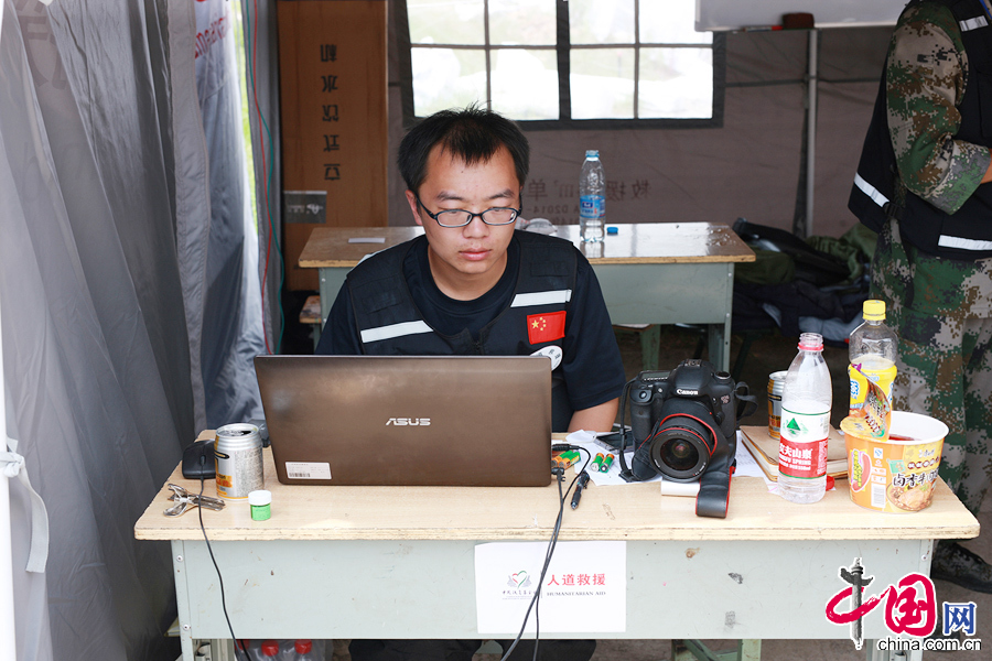 扶贫基金会在鲁甸的大本营工作现场，桌椅、电脑、相机、泡面、水。 中国网记者 杨佳摄影