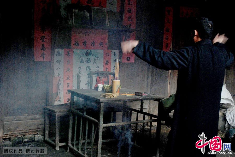 在湖南省新邵县坪上镇，一场木偶戏表演前，木偶戏的传承人在烧纸敬香请师爷。