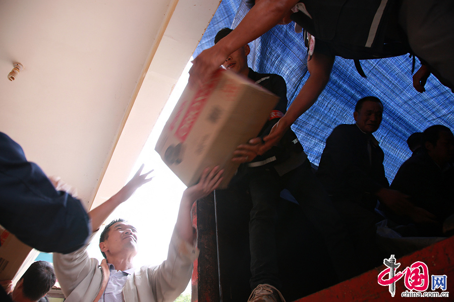 2014年8月11日，云南鲁甸火德红镇救援点，工作人员将救援物资搬运到货车上。