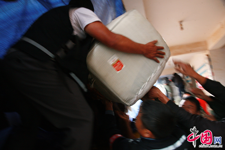 2014年8月11日，云南鲁甸火德红镇救援点，一些救援物资过重，需要好几名志愿者一起协作。