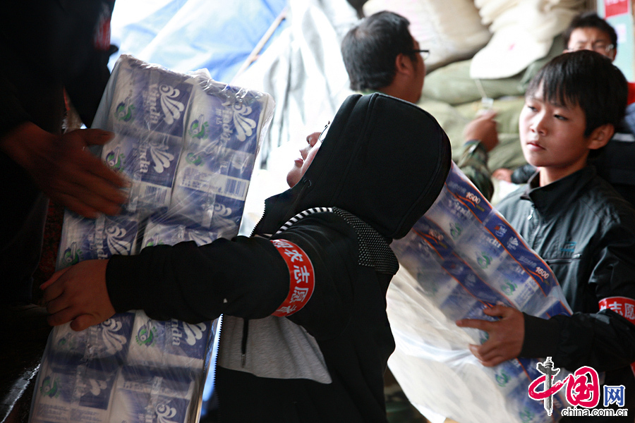 2014年8月11日，云南鲁甸火德红镇救援点，许多孩子也来帮忙，搬运较轻的物资。