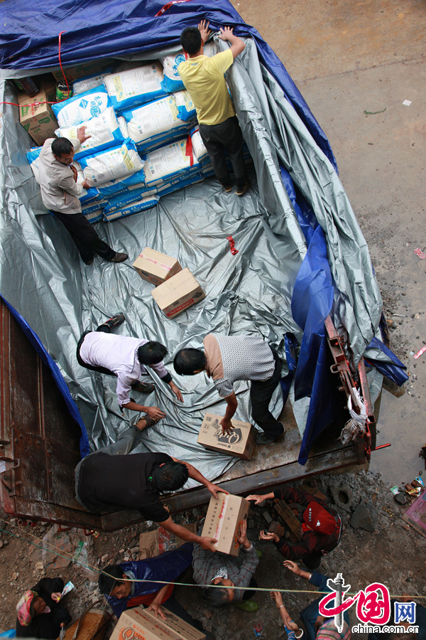 2014年8月11日，云南鲁甸南筐村，众人合力将货车上的救援物资搬运下来。