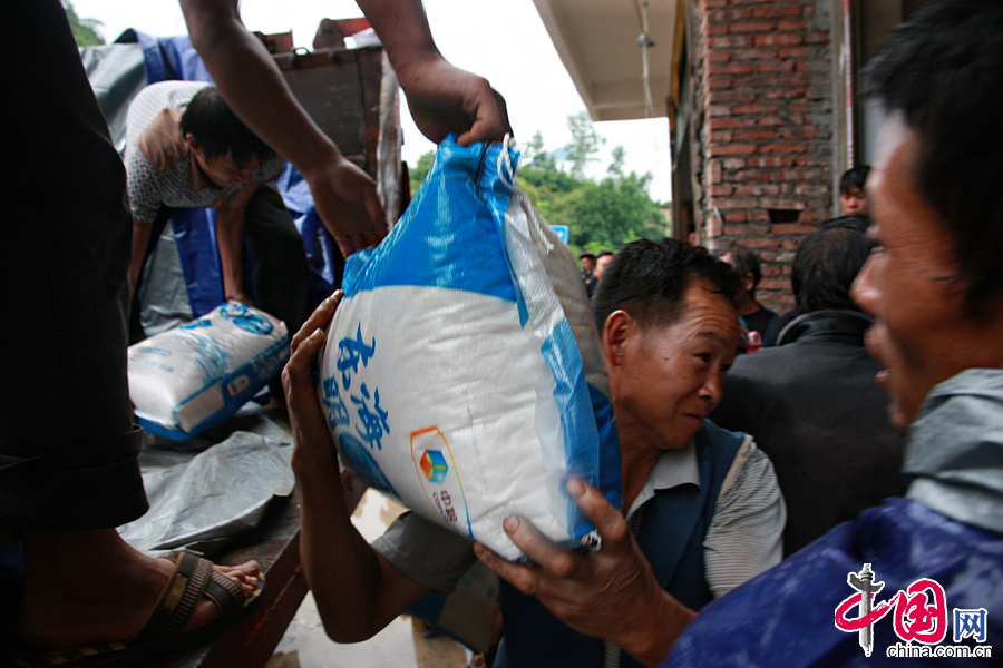 2014年8月11日，云南鲁甸南筐村，许多村民也自发加入到搬运队伍中，将救援物资卸下货车。