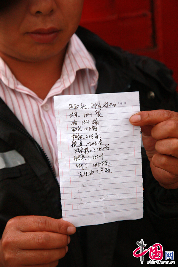 2014年8月11日，云南鲁甸南筐村，工作人员向记者展示运抵的救援物资。