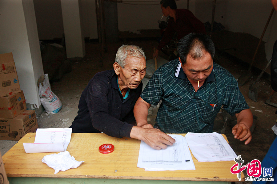 2014年8月11日，雲南魯甸南筐村，村長和社長正在清點核對救援物資。