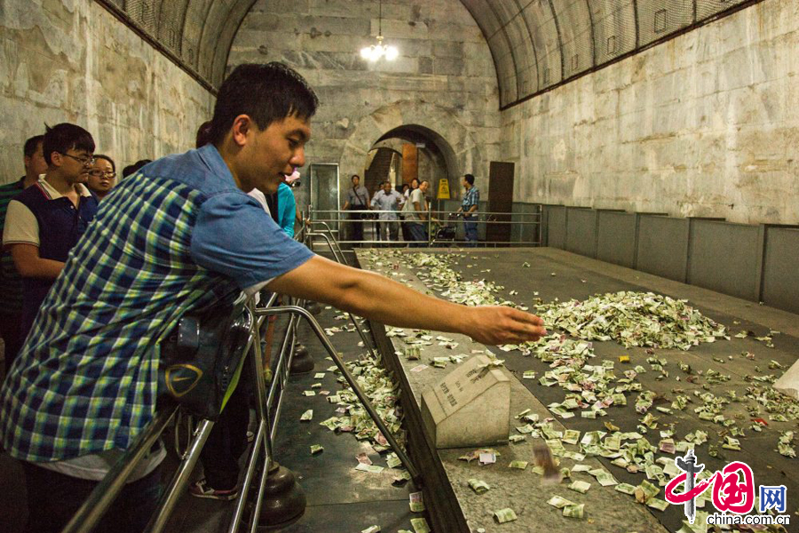 2014年8月14日，北京昌平区，5A级景区明十三陵定陵地宫内，历史文物上游客祈福所投过去的钱币堆成了小山，没有工作人员制止或进行清理。