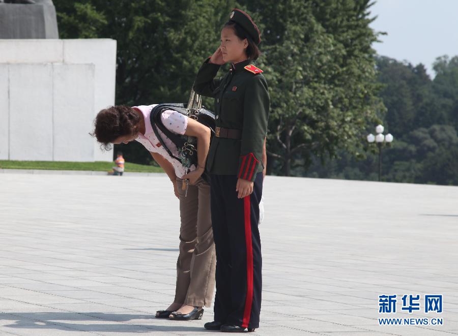 8月15日,在北韩平壤,人们在万寿台广场献花后鞠躬.