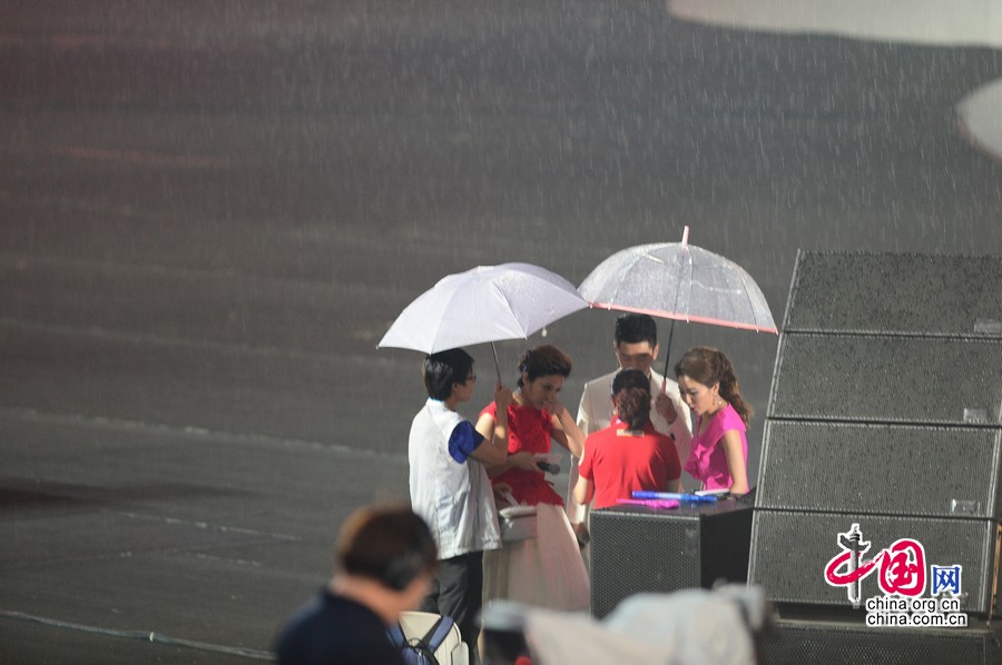 2014年8月16日晚20点，大雨突袭第二届夏季青年奥运会开幕式现场，组委会工作人员迅速在开幕式场地上覆盖雨布，主持人也打起早已准备好的雨伞继续节目进行。