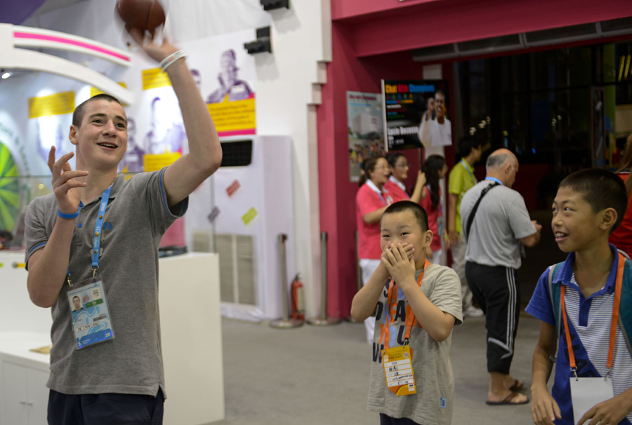 2014年8月18日，南京青奥村，刘郎（右一）和顾博文（中）在奥运村跟外国运动员比投篮。