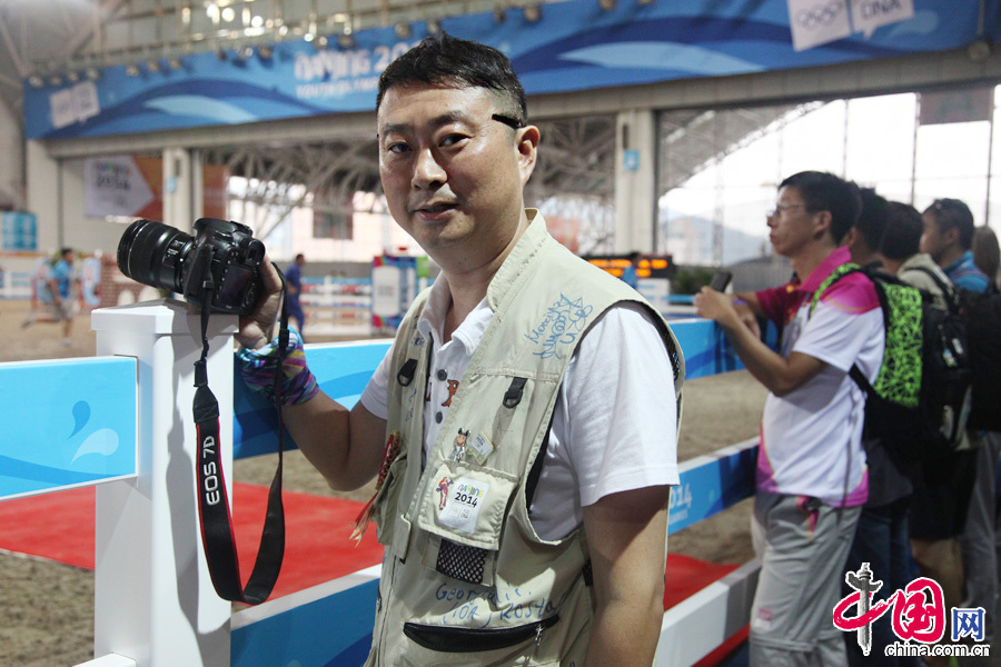 8月20日，南京青奥会，青奥马术赛场上一名报道记者的马甲签满名字。