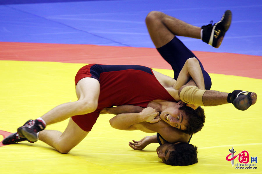  8月27日，俄罗斯选手阿米尔汉·古瓦若科夫（左）在青奥会摔跤男子自由式54公斤级小组预赛中将新西兰选手布拉姆·理查兹摔倒。中国网 李佳 摄影