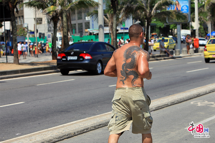 海滩公路上中国龙的纹身跑步男