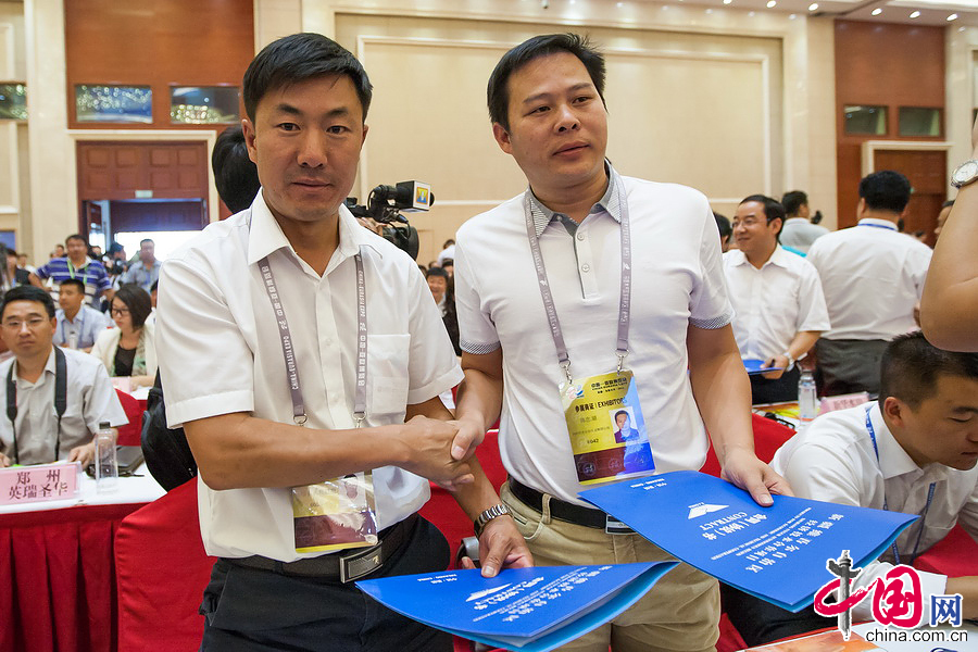 2014年9月2日，亞歐博覽會“共建絲綢之路經濟帶推介會暨重點項目簽約儀式”在烏魯木齊召開。圖為與會代表簽約結束後握手祝賀。中國網記者 鄭亮攝影