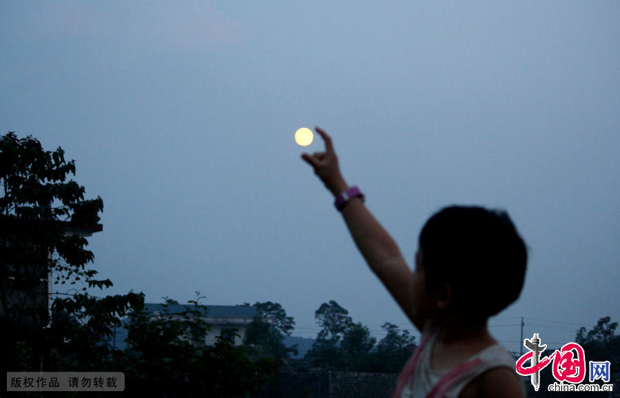 9月8日，湖南省涟源市桥头河镇一小孩在赏月戏月。中国网图片库 张扬摄影