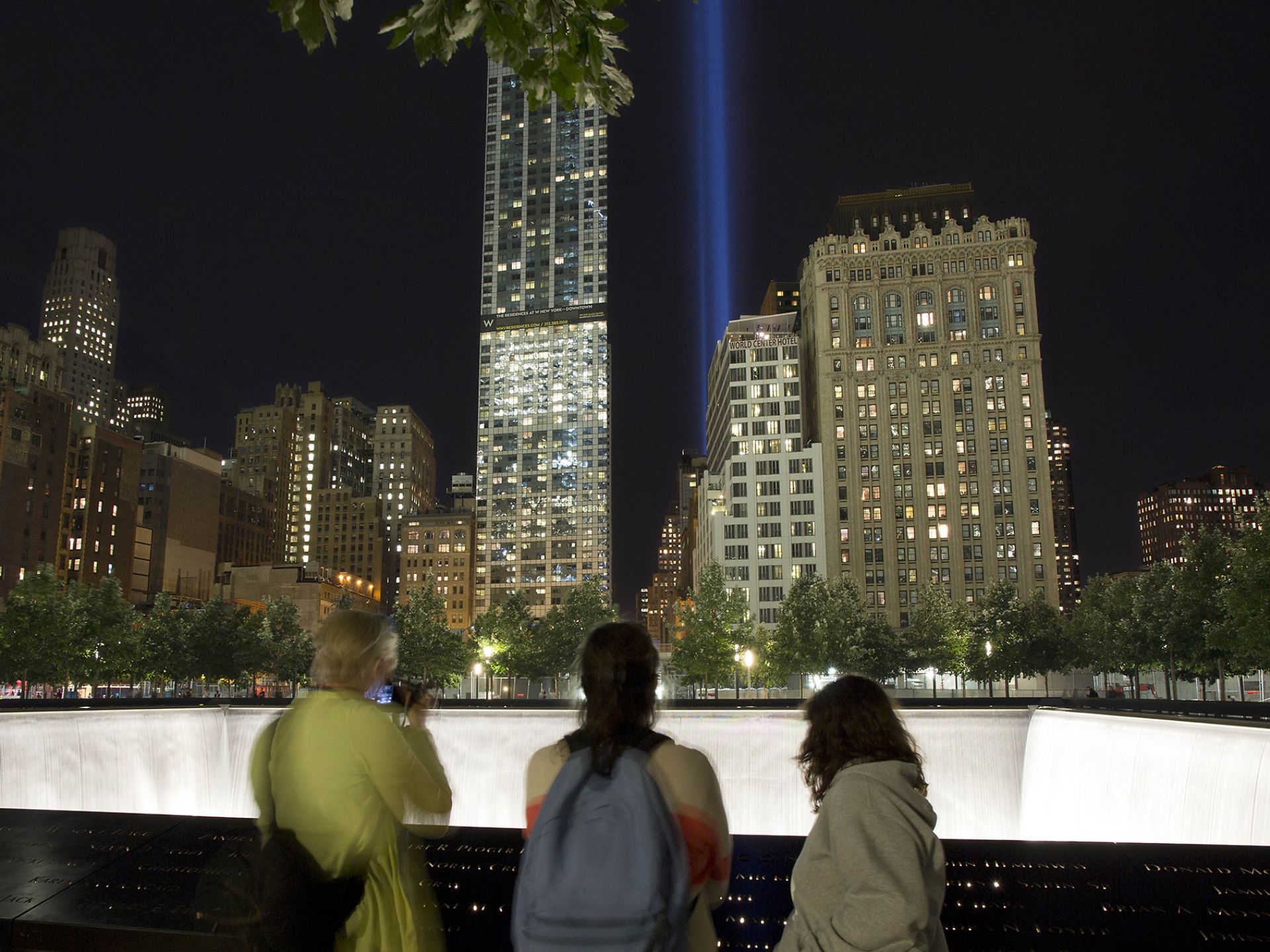 遊客們在911國家紀念日觀看在世貿大樓原址射向天空的燈光。